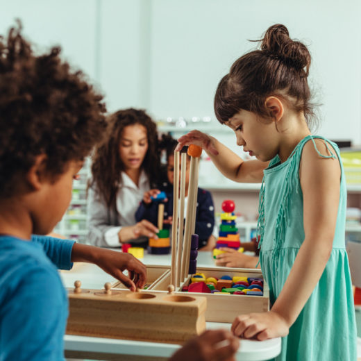 Un grupo de niños jugando con bloques de madera en un aula.
