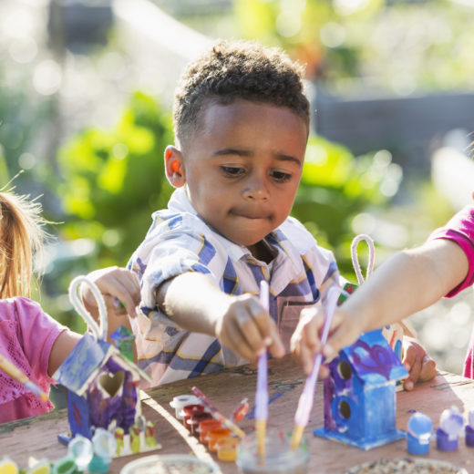 Un grupo de niños jugando con juguetes en un jardín.