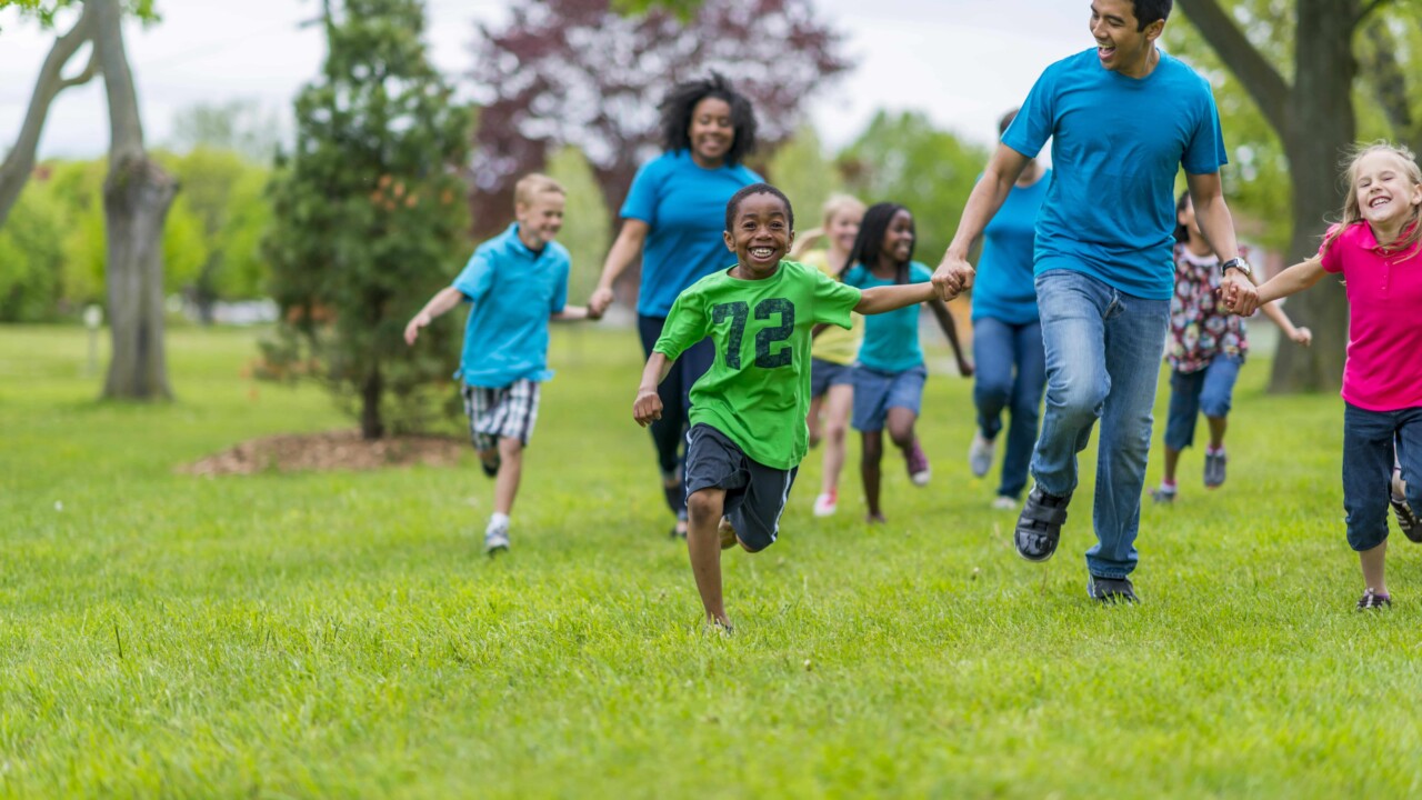 Kids and adults racing and holding hands.